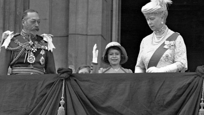 Princess Elizabeth (C) waves on the balcony of Buckingham Palace, with her grandparents King George V and Queen Mary, in 1935.