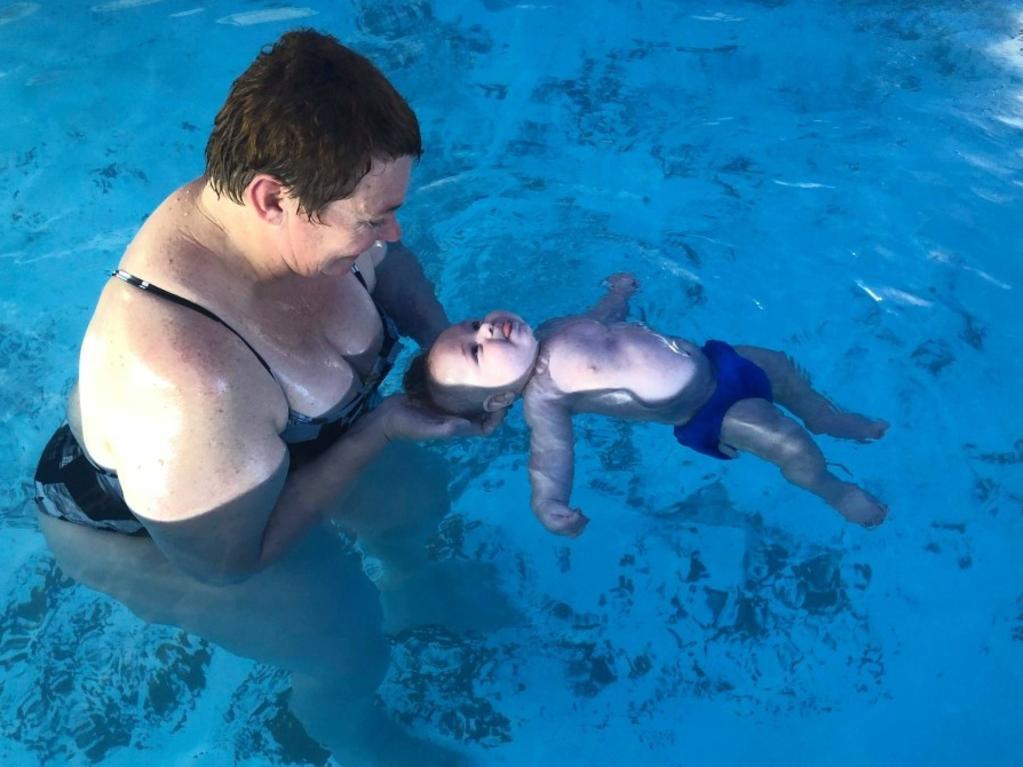 Caribeae Swimming Academy head coach Jodie Shanks with grandchild Hudson Heinemann-Little having his first lesson at three weeks old.