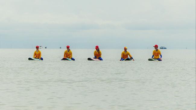 Members of the Arcadian SLSC at Net 1, The Strand, observe a moment of silence for Surf Life Saving memorial Day. Picture: Blair Jackson.