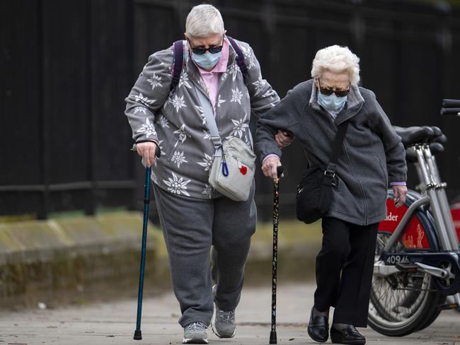 Elderly members of the public wearing face masks walk down a street in Central London. Picture: Getty Images