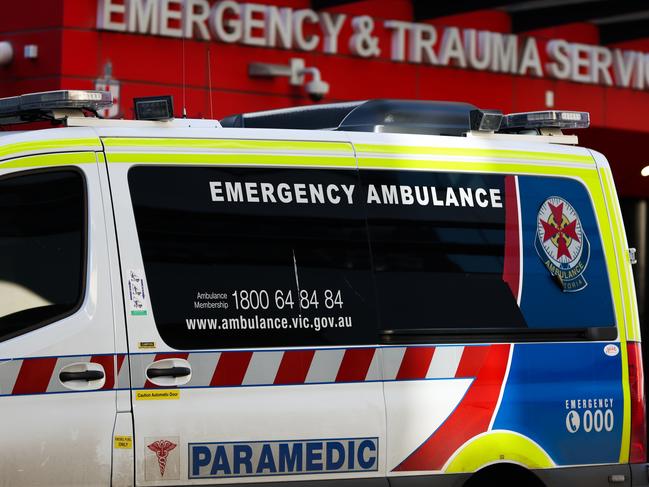 MELBOURNE, AUSTRALIA - JULY 21: An ambulance is parked in front of the Emergency & Trauma service at the Royal Melbourne Hospital on July 21, 2022 in Melbourne, Australia. Victoria recorded 14,312 official cases of COVID-19 in the last 24-hour reporting period, with 875 people hospitalised with the virus, including 46 in intensive care. 37 deaths were also included in this reporting period. While the Federal government has not implemented any COVID-19 restrictions in response to the latest COVID-19 wave, concerns over rising cases of the Omicron subvariants across Australia have seen health authorities recommend the use of face masks indoors, and for people to work from home where possible. (Photo by Asanka Ratnayake/Getty Images)