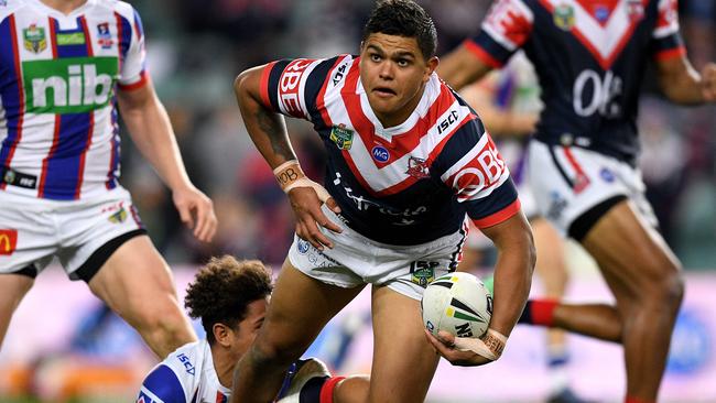 Latrell Mitchell of the Roosters is tackled by Dane Gagai.
