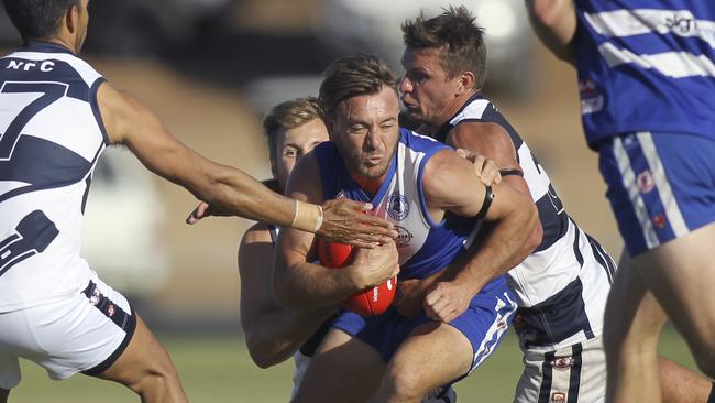 Port Noarlunga's Aaron Peterson tries to break past Noarlunga's Terry Milera, while being tackled by Sam Miller and Jarrad Liebelt. Picture: AAP/Dean Martin