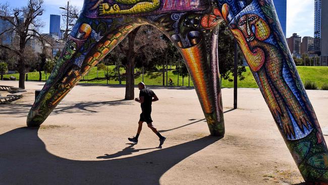 A jogger runs past Debrah Halpern’s ‘Angel’ sculpture, along the Yarra River. Picture: AFP