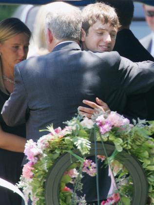 John Ramsey hugs his son, Burke at the graves of his wife, Patsy, and daughter JonBenet in 2006.