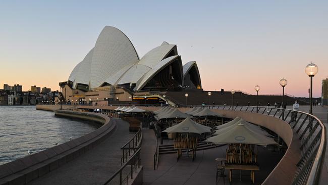 Tables and chairs sit empty at Circular Quay, usually full of visitors, on the first full day of the two-week coronavirus lockdown. Photo: Steven Saphor/AFP