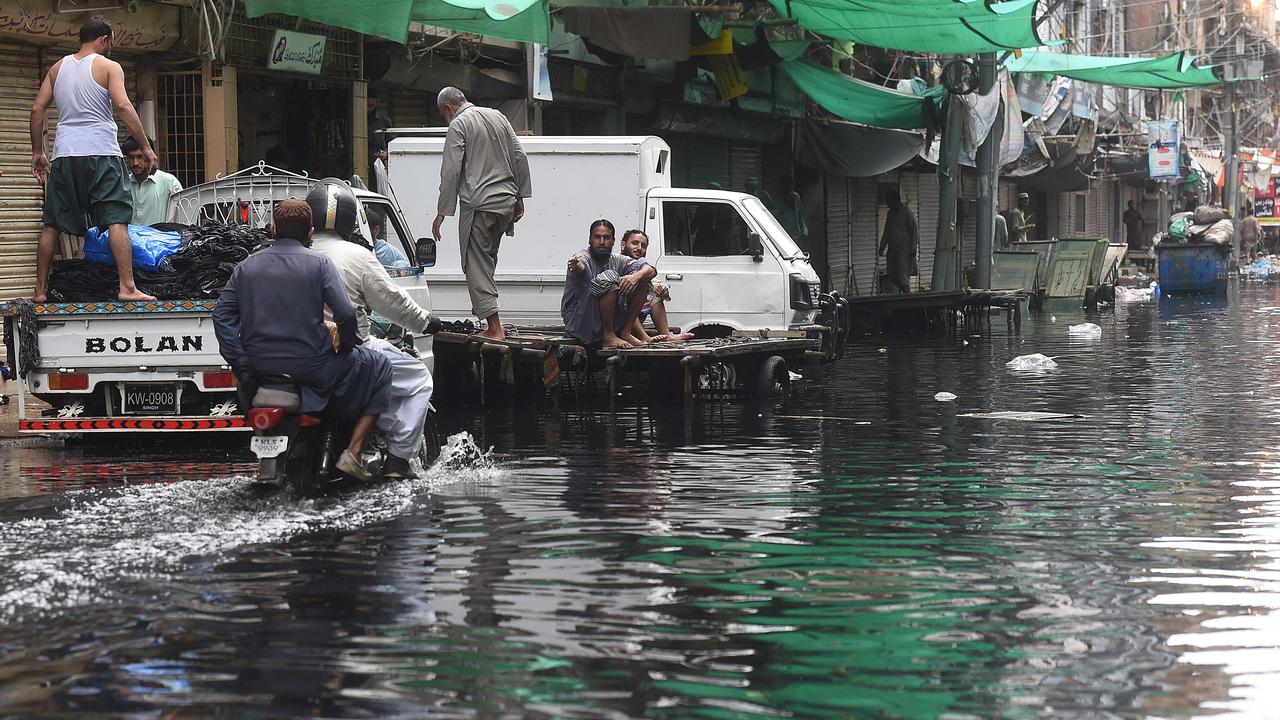 Men ride on a motorbike along a flooded street after heavy monsoon rains in Pakistan's port city of Karachi on August 31. Picture: Asif Hassan/AFP