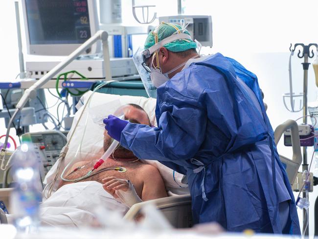 A medical worker wearing a face make and protection gear tends to a patient inside the new coronavirus intensive care unit of the Brescia Poliambulanza hospital, Lombardy. Picture: AFP