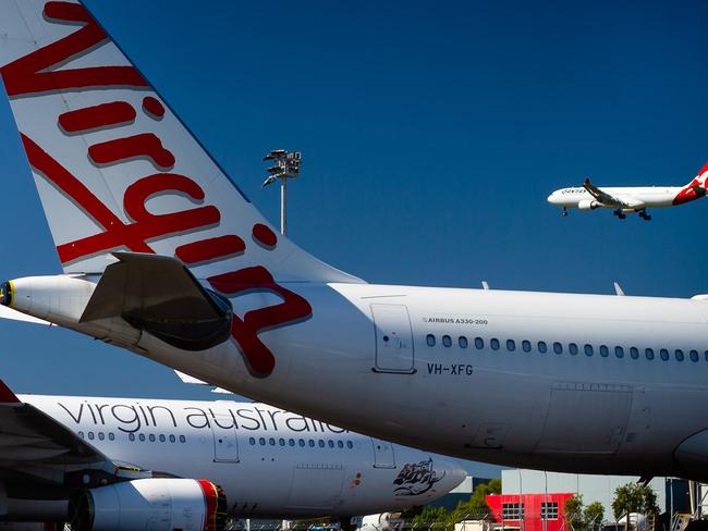 Virgin Australia aircraft are seen parked on the tarmac at Brisbane International airport on April 21, 2020. - Cash-strapped Virgin Australia collapsed on April 21, making it the largest carrier yet to buckle under the strain of the coronavirus pandemic, which has ravaged the global airline industry. (Photo by Patrick HAMILTON / AFP)