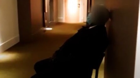 A guard was filmed asleep outside a hotel door. Picture: Four Corners/ABC