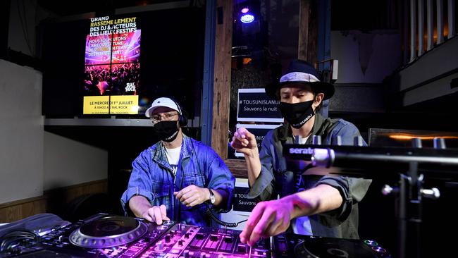 It’s not just in South Australia that nightclubs are closed: DJs wearing face masks reading "I am DJ" perform at the Balrock bar in Paris during an event to protest the continued closure of nightclubs. Picture: AFP