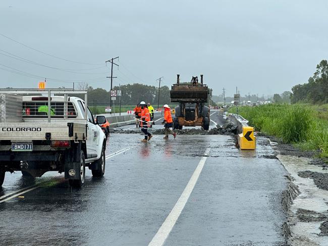 Floods had closed off the Bruce Highway at Calen, as crews worked with a bobcat to remove the rubble. Picture: Heidi Petith.