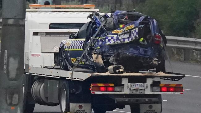 A mangled highway patrol car is towed from the scene. Picture: AAP