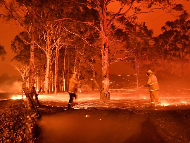This timed-exposure image shows firefighters hosing down trees as they battle against bushfires around the town of Nowra in the Australian state of New South Wales on December 31, 2019. - Thousands of holidaymakers and locals were forced to flee to beaches in fire-ravaged southeast Australia on December 31, as blazes ripped through popular tourist areas leaving no escape by land. Picture: Saeed Khan/AFP