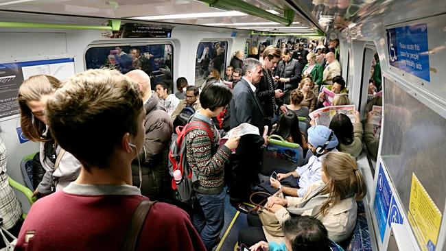 Commuters cram on to a packed train in peak hour.