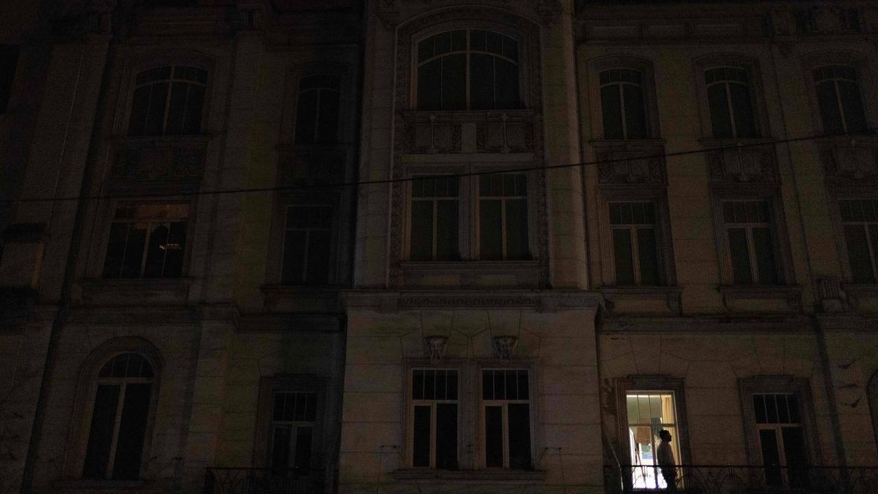 A person stands on a balcony of a theatre building during a partial blackout in Kyiv. Picture: AFP