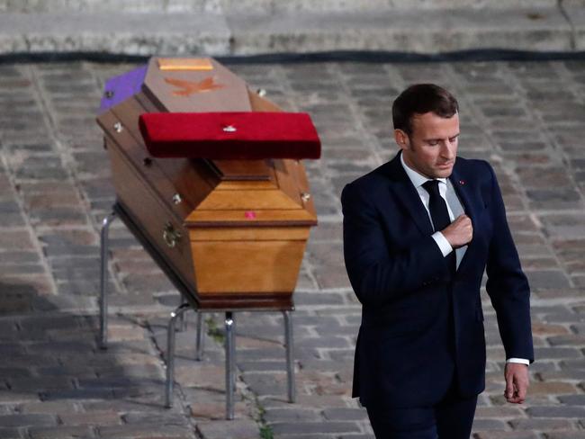 TOPSHOT - French President Emmanuel Macron pays his respects by the coffin of Samuel Paty's coffin inside Sorbonne University's courtyard in Paris on October 21, 2020, during a national homage to French teacher Samuel Paty, who was beheaded for showing cartoons of the Prophet Mohamed in his civics class. - France pays tribute on October 21 to a history teacher beheaded for showing cartoons of the Prophet Mohamed in a lesson on free speech, an attack that has shocked the country and prompted a government crackdown on radical Islam. Seven people, including two schoolchildren, will appear before an anti-terror judge for a decision on criminal charges over the killing of 47-year-old history teacher Samuel Paty. (Photo by Francois Mori / POOL / AFP)