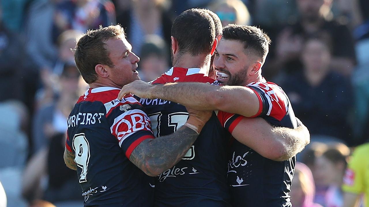 Roosters players celebrate a try against the Titans.