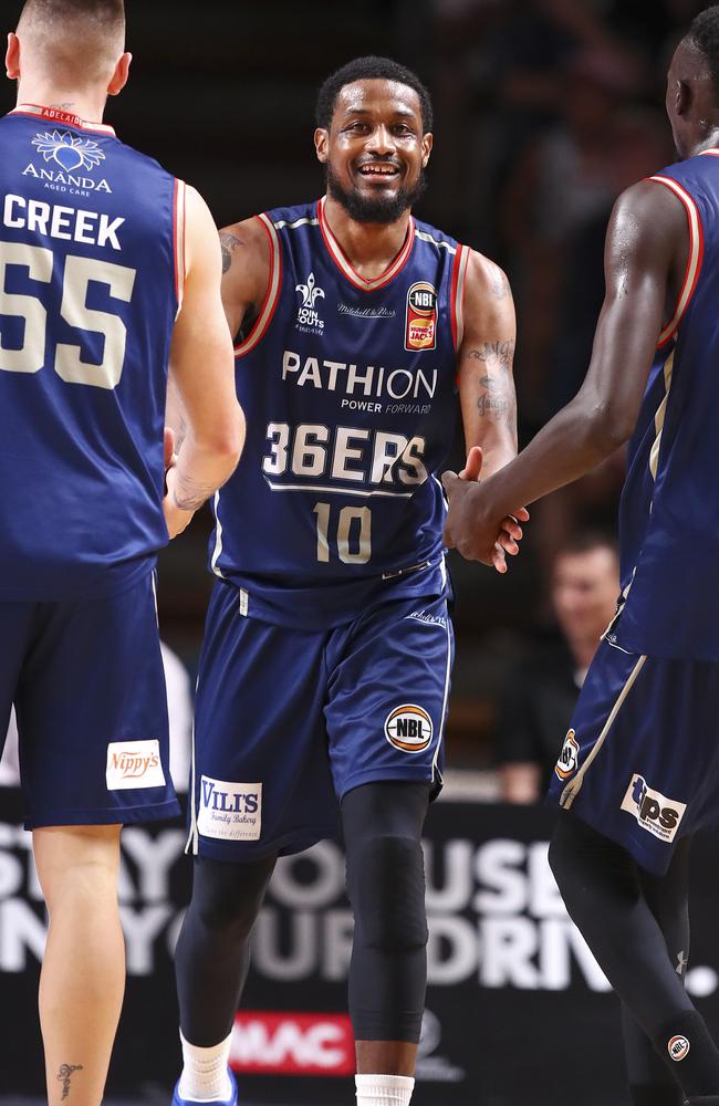 Adelaide 36ers’ Ramone Moore congratulated by Mitch Creek and Majok Deng.