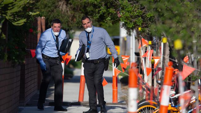 Detectives at the scene speak to neighbouring homes. Picture: Sarah Matray