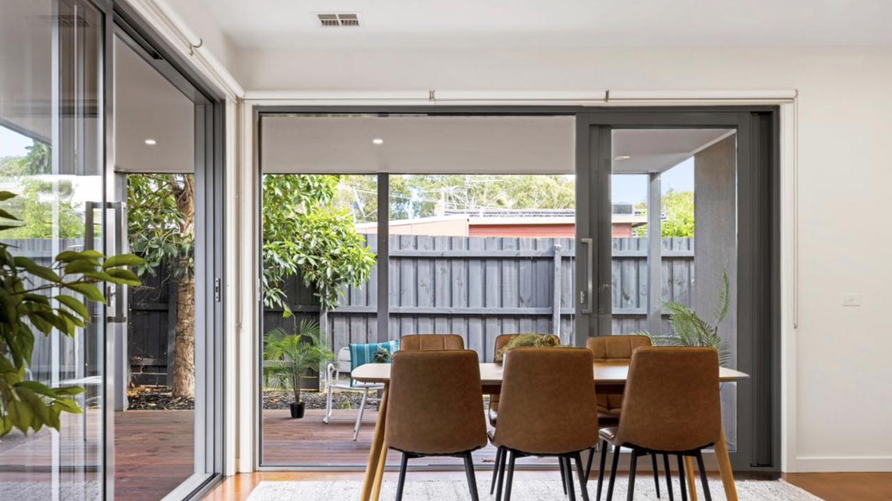 The expansive open-plan living zone connects effortlessly with the kitchen and decked alfresco for everyday ease.