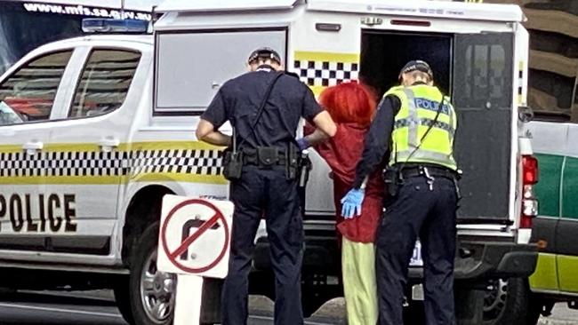 A protester is arrested after being removed from the balcony roof. Picture: Patrick James