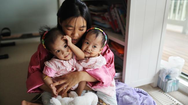 Nima, right, and Dawa, left, being held by their mother Bhumchu before their surgery. Picture: Alex Coppel