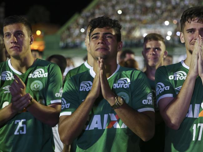 Chapecoense soccer players who did not travel with their team on a flight to Colombia that crashed, mourn during a tribute to the crash victims. Picture: AP/Andre Penner