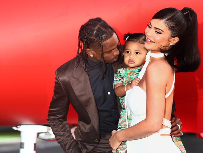 Kylie Jenner (pictured with partner Travis Scott and daughter Stormi) has made a make-up line mandatory for big stars. Picture: Getty