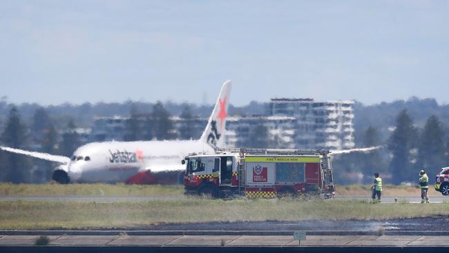 Emergency services on the runway following the engine failure and grass fire. Picture: Liam Mendes