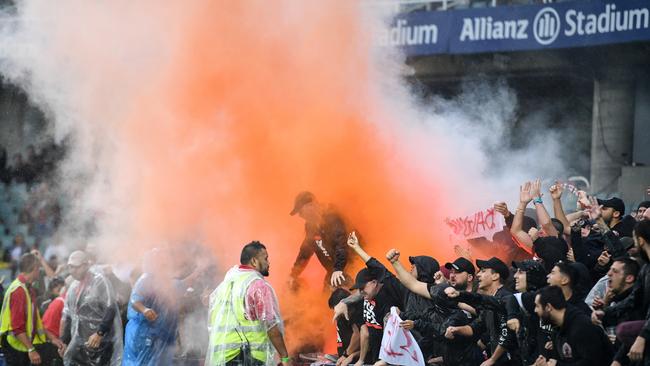 Members of the Wanderers supporting group Red and Black Bloc light a flare at a match in February 2018 Picture: AAP