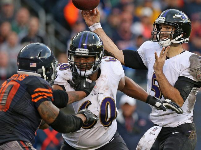 CHICAGO, IL - NOVEMBER 17: Joe Flacco #5 of the Baltimore Ravens passes as Eugene Monroe #60 blocks Julius Peppers #90 of the Chicago Bears at Soldier Field on November 17, 2013 in Chicago, Illinois. The Bears defeated the Ravens 23-20 in overtime. (Photo by Jonathan Daniel/Getty Images)