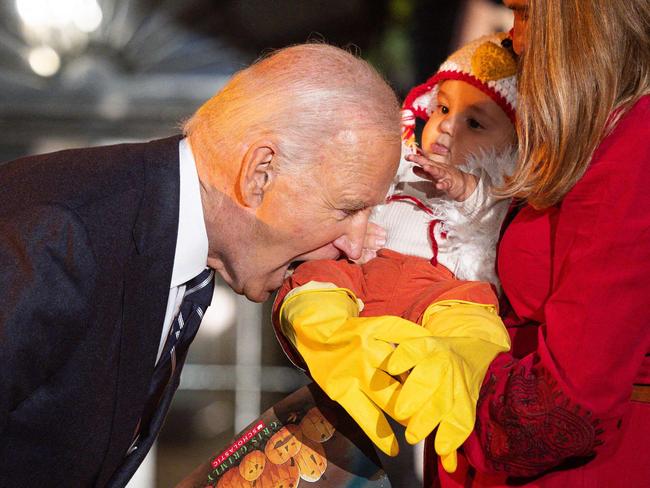 TOPSHOT - US President Joe Biden jokingly bites a baby dressed as a chicken as he hosts a Halloween trick-or-treat event at the South Portico of the White House in Washington, DC, on October 30, 2024. (Photo by Tierney CROSS / AFP)