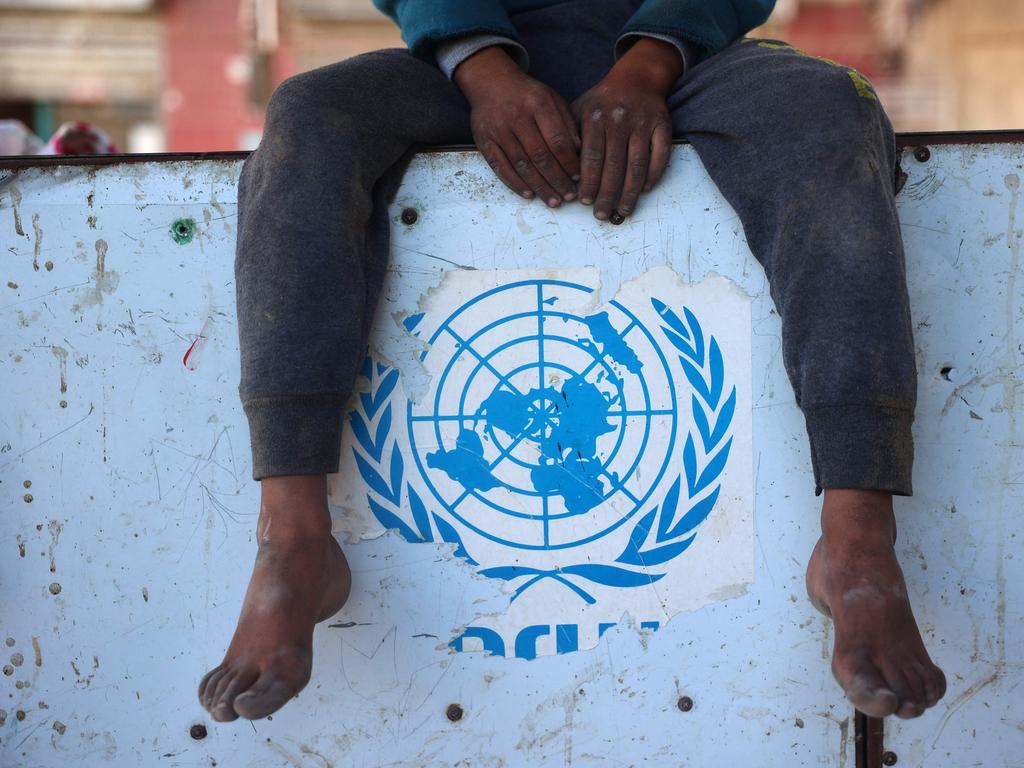 A Palestinian boy sits over a torn UNRWA sticker in Nuseirat in the central Gaza Strip on December 2, 2024, amid the ongoing war between Israel and Hamas militants. Picture: Eyad Baba / AFP