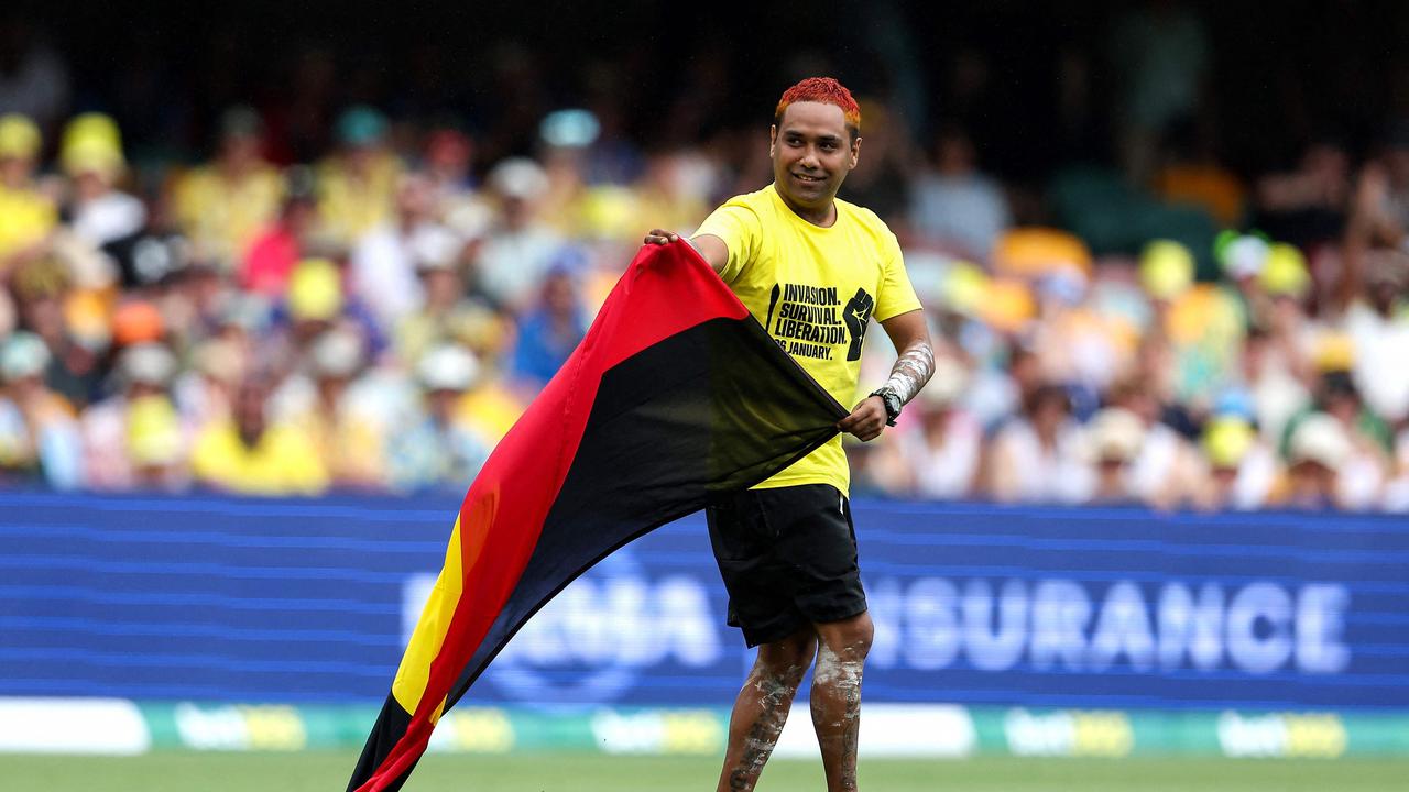 A pitch invader with an Australian Aboriginal flag is seen on the field during day two of the second cricket Test match between Australia and West Indies at the Gabba. Picture: AFP