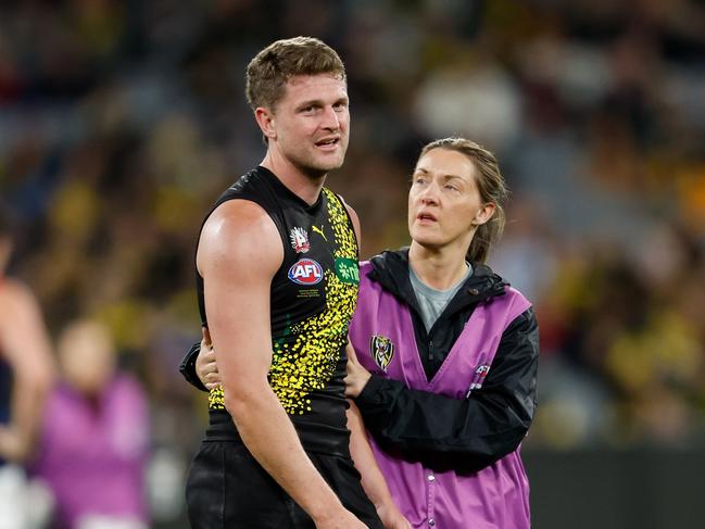 MELBOURNE, AUSTRALIA - APRIL 24: Jacob Hopper of the Tigers is seen to by medical staff during the 2024 AFL Round 07 match between the Richmond Tigers and the Melbourne Demons at the Melbourne Cricket Ground on April 24, 2024 in Melbourne, Australia. (Photo by Dylan Burns/AFL Photos via Getty Images)