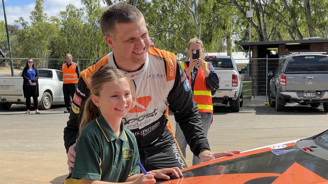 Mannum student Teghan Reichstein was one of a group of kids to sign V8 Supercar driver Brodie Kostecki's bonnet on Wednesday. Photo: Dylan Hogarth.