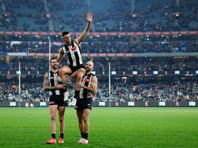 And being chaired off the MCG by teammates Jeremy Howe and Steele Sidebottom. Picture: Dylan Burns/AFL Photos