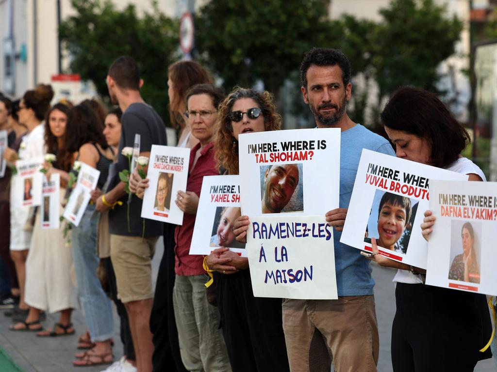 People carry placards bearing pictures of missing persons in Tel Aviv. Picture: Ahmad Gharabli/AFP