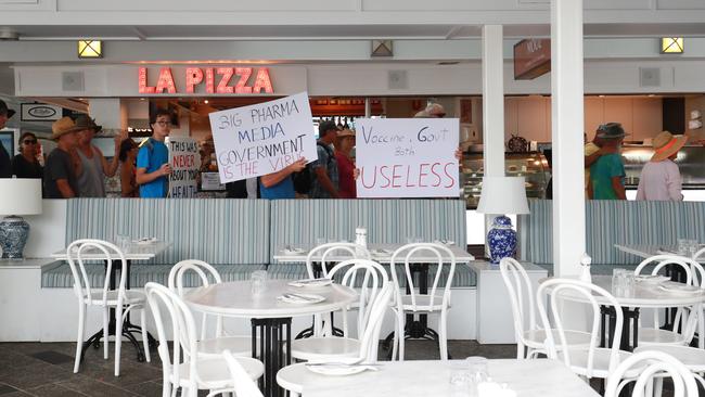 A large crowd up to 1500 people attended the Worldwide Rally for Freedom north of Muddy's Playground, before marching down the Esplanade and through the Cairns CBD. Protesters march past La Pizza alfresco restaurant on Aplin Street. Picture: Brendan Radke