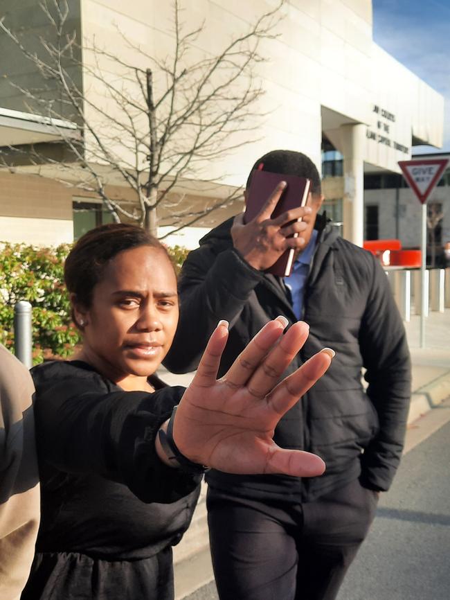 Simon Vunilagi (right) leaves the ACT Supreme Court while supporters unleash a tirade of abuse the threats of violence. Picture: Craig Dunlop