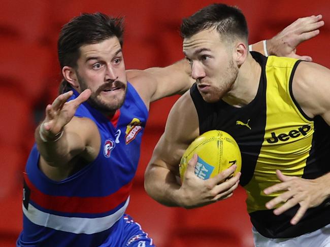 AFL Round 9. Western Bulldogs vs Richmond at Metricon Stadium, Gold Coast. 29/07/2020.   Noah Balta of the Tigers clears infront of Josh Bruce of the Bulldogs    . Pic: Michael Klein