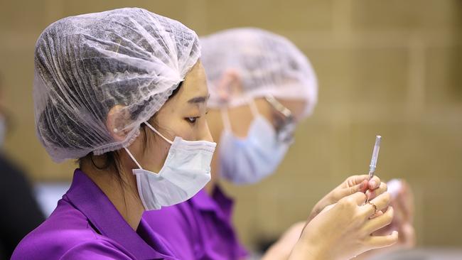 Clinical staff label drawn up AstraZeneca COVID-19 syringes at t a Perth vaccination clinic. Picture: Paul Kane/Getty Images