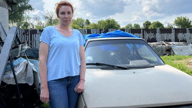 Oksana Serhiienko with the car she was driving when Russian soldiers shot at her.