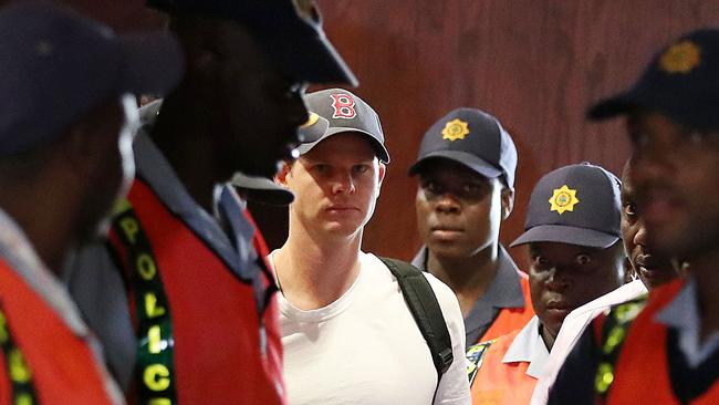 Australian cricket player Steve Smith, escorted by police officers to a departure area at OR Tambo International airport in Johannesburg, South Africa, Wednesday, March 28, 2018. Steve Smith, vice-captain David Warner and batsman Cameron Bancroft are being sent home from South Africa for ball-tampering in the third Test in Cape Town. Photo: WP Media