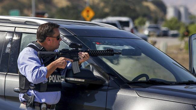 A police officer provides cover during the search for a man who wounded a sheriff's deputy and killed a transient continues in Paso Robles, California Picture: AP