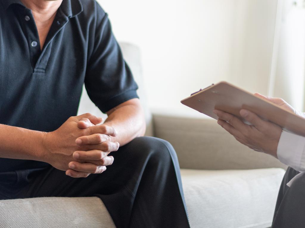 Doctor physician consulting with male patients in hospital exam room. Men's health concept