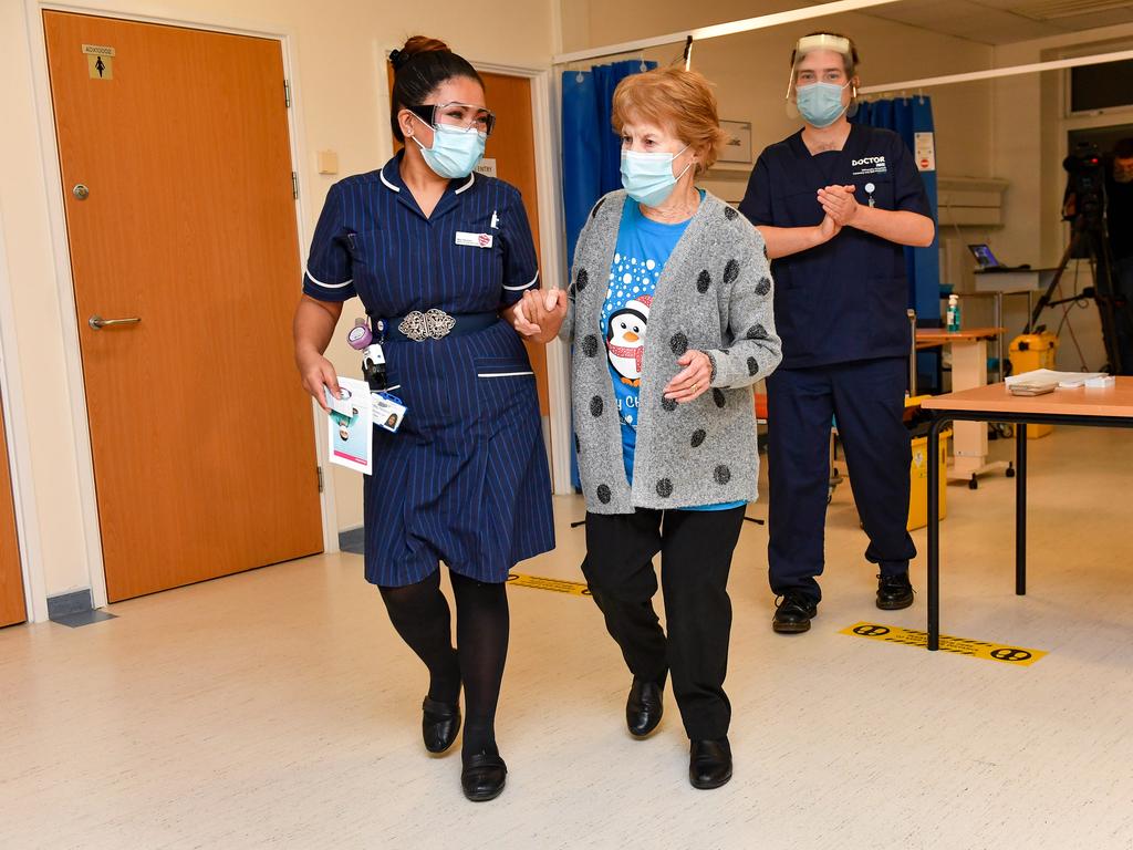 Margaret Keenan, 90, walks with nurse May Parsons after becoming the first patient in the United Kingdom to receive the Pfizer/BioNTech vaccine. Picture: Getty Images