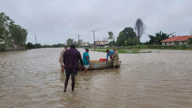 Residents of Burketown help others move their belongings to higher ground as flooding impacts the regional area.