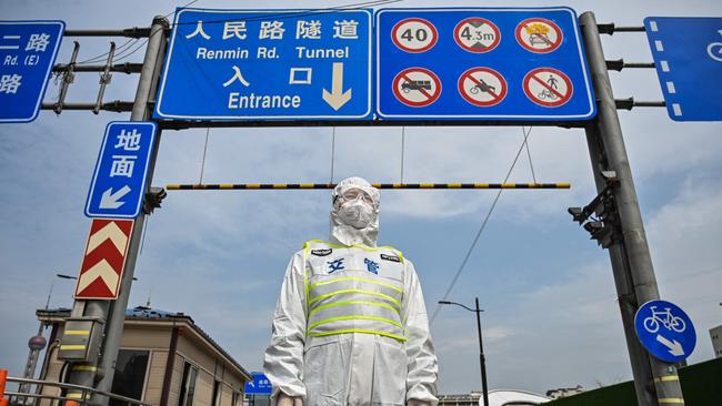 A transit officer wearing protective gear controls access to a tunnel in the direction of the Pudong district in Shanghai under lockdown as part of China’s Covid-zero policy.